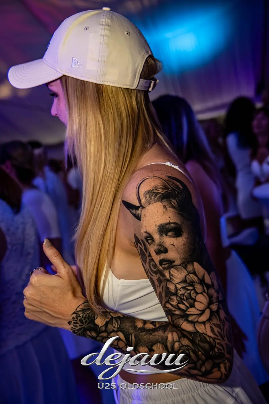 Frau mit Tattoo-Sleeve und Cap tanzt